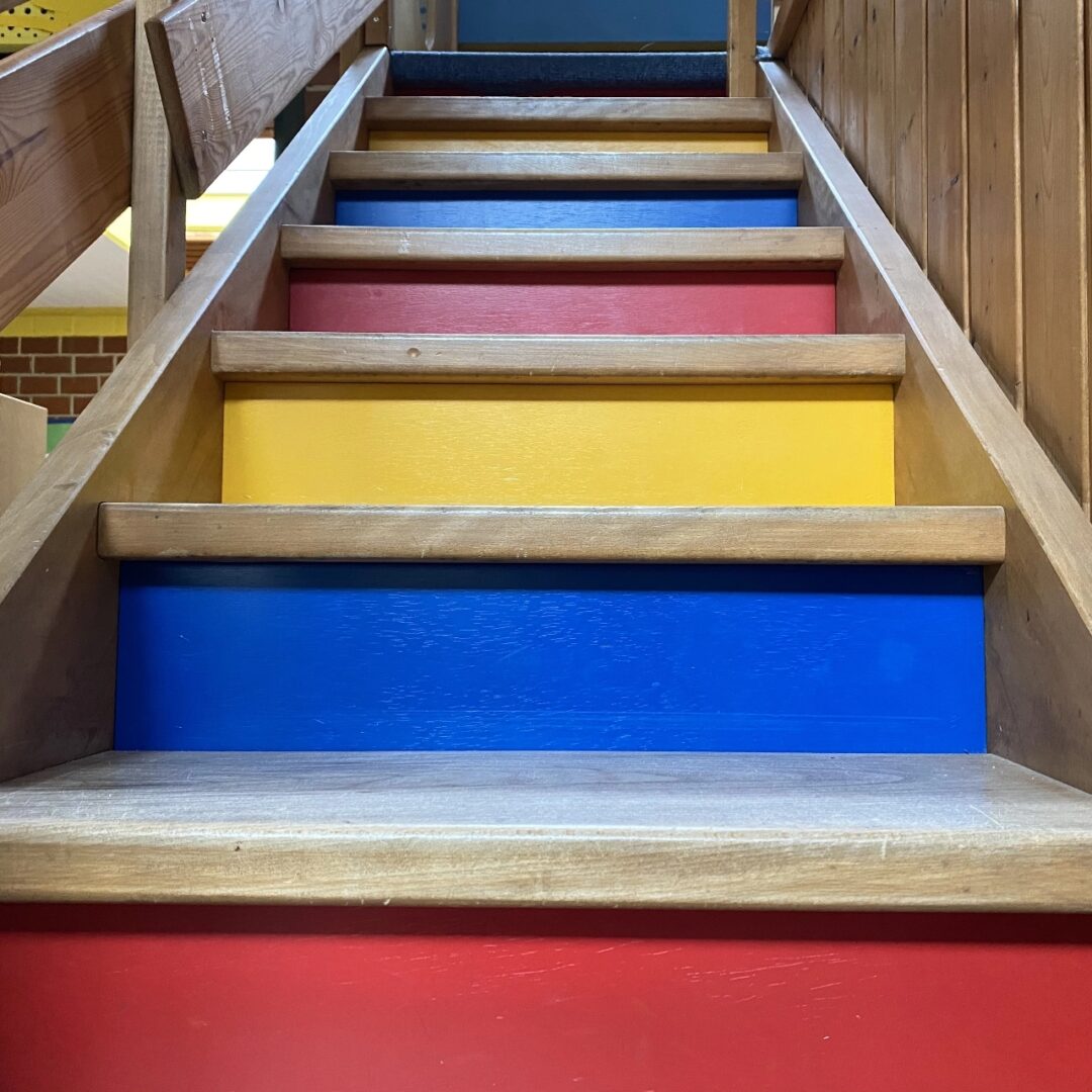 Nahaufnahme des bunten Treppenaufgangs eines maßgefertigten Spielhaus der Schreinerei Marc Hoffmann