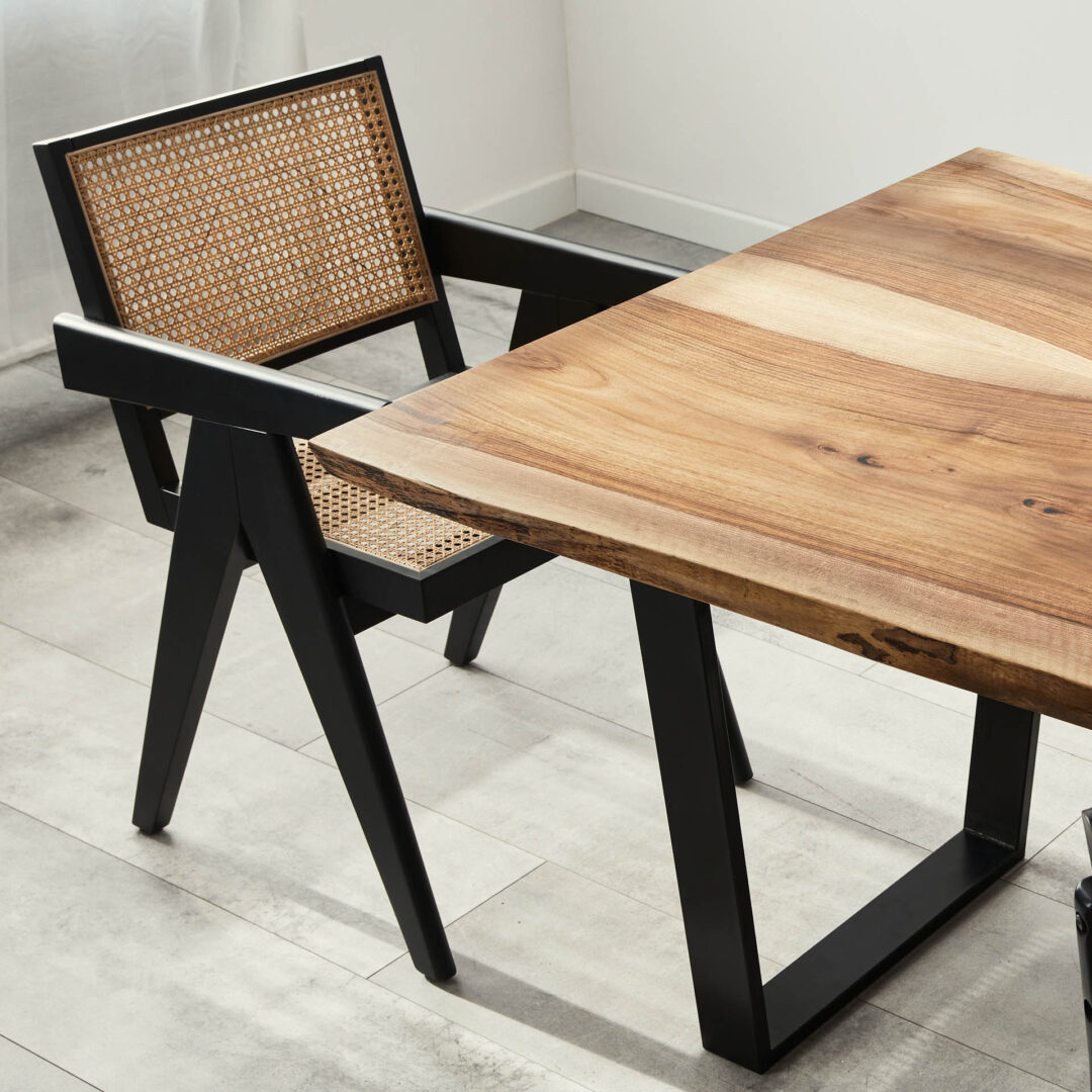Baumkanten-Tischplatte aus mittelbraunem Holz auf schwarzen Metallbeinen in U-Form