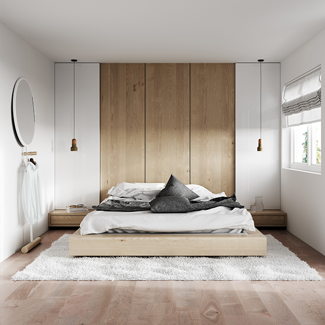 Bett mit breitem Rahmen auf einem Hochflorteppich in einem hellen Schlafzimmer in Naturtönen
