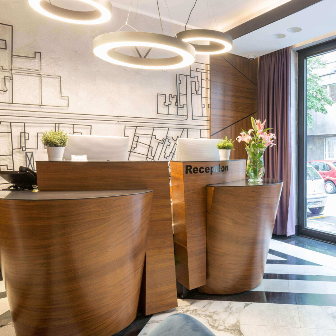 Zwei Empfangstheken einer Hotelrezeption mit zwei eigenständigen Arbeitsplätzen in ausgefallenem Holz-Design