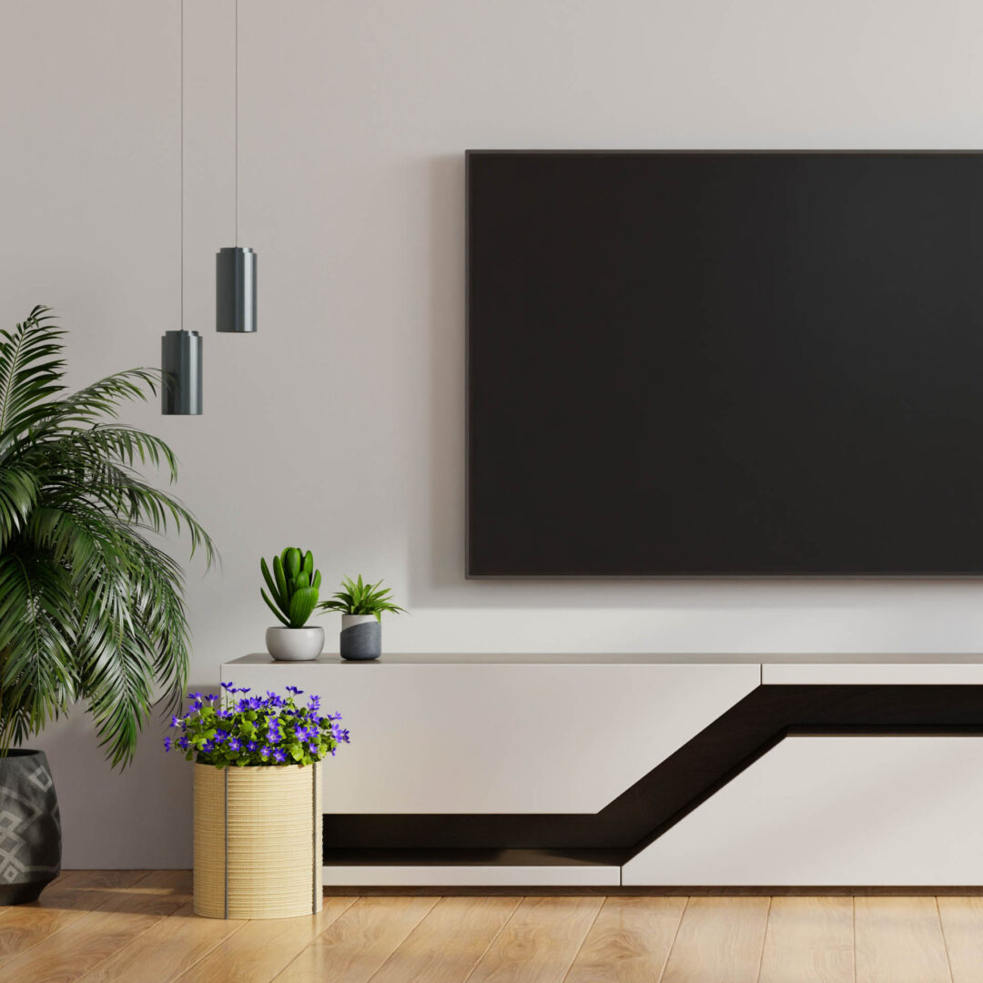 Ausgefallenes HiFi-Möbel aus weißen Fronten mit einem Strich aus dunklem Glas unter einem hängenden Fernseher